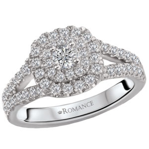 This is an elegant bridal ring created in 14k white gold that features round faceted diamonds displayed along the split shank that surrounds the double halo center.
