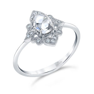 An oval rose-cut diamond glows within an artistic halo of brilliant white diamonds and fine milgrain detailing atop gleaming high polished gold in this feminine and stunning design from the Lumiere Bridal Collection.